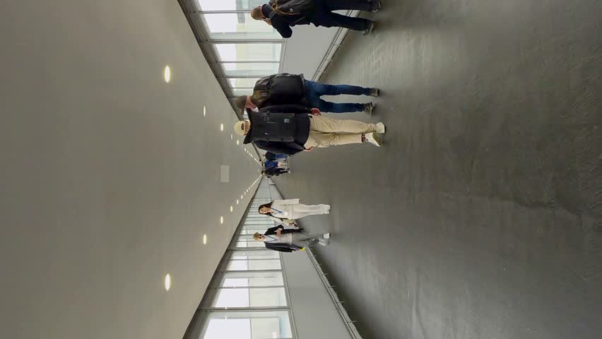 Vertical video, Hyperlapse, POV view of passage across the bridge from the train station to Barcelona airport