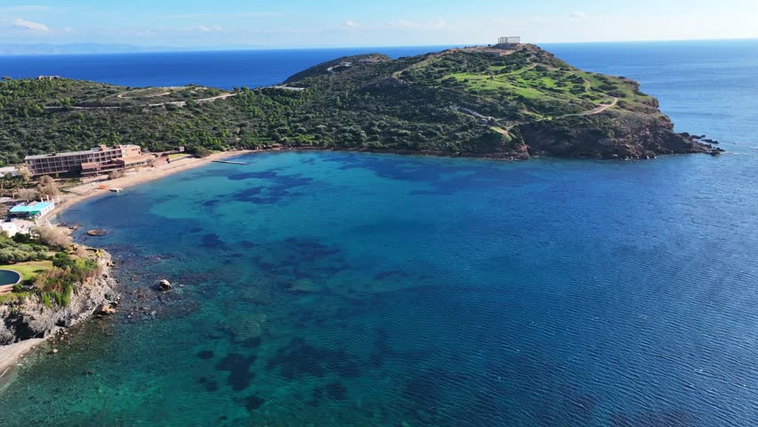 Aerial drone video of iconic archaeological site of Cape Sounio and famous Temple of Poseidon built uphill overlooking Aegean sea, Attica, Greece
