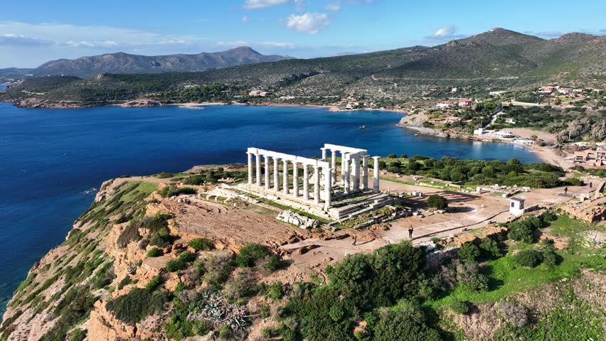 Aerial drone video of iconic archaeological site of Cape Sounio and famous Temple of Poseidon built uphill overlooking Aegean sea, Attica, Greece