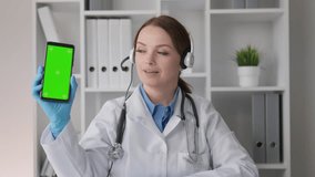 Patients health in spotlight Doctor conducts video conferences and consults online, providing high-quality medical service. Chroma key and green screen on phone, promoting website, app and promotion
