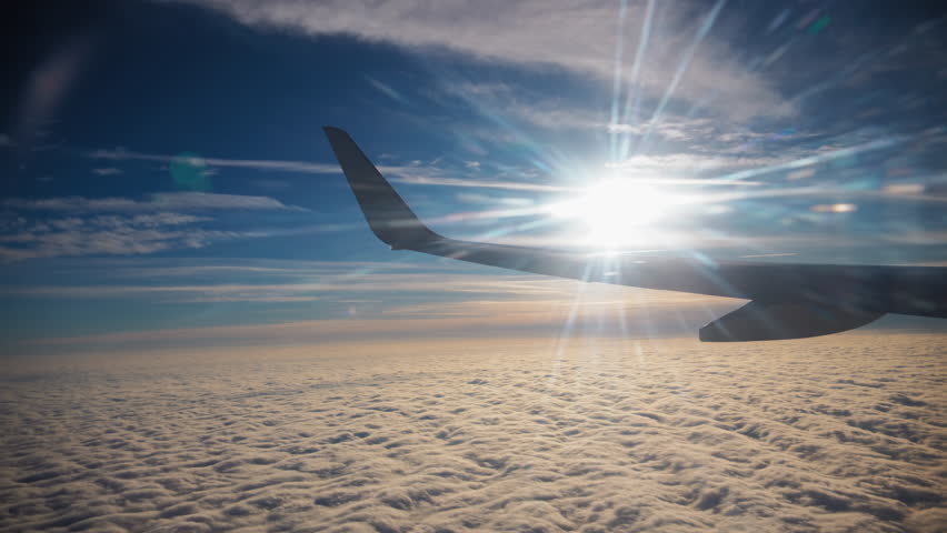 Wide view shot of porthole and Blue sky and big white clouds, from the airplane porthole on day time