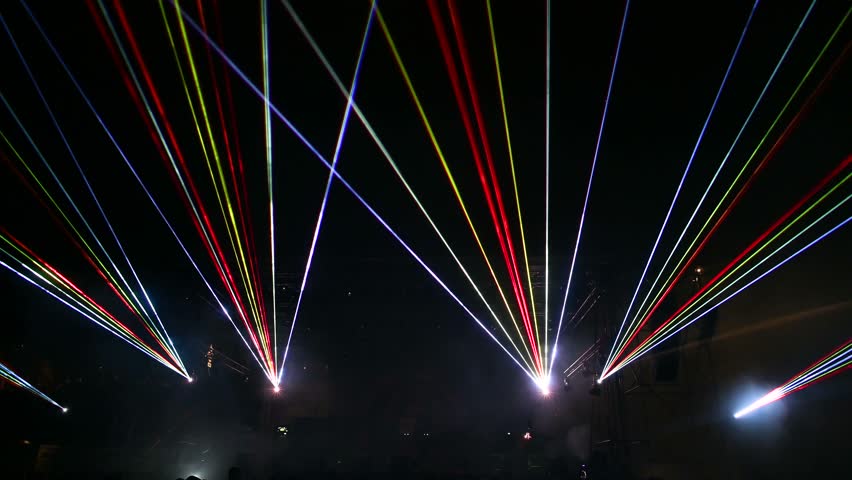 Laser lights and fog on the stage during concert. Multicolored light show at night. Abstract background. Laser beam.