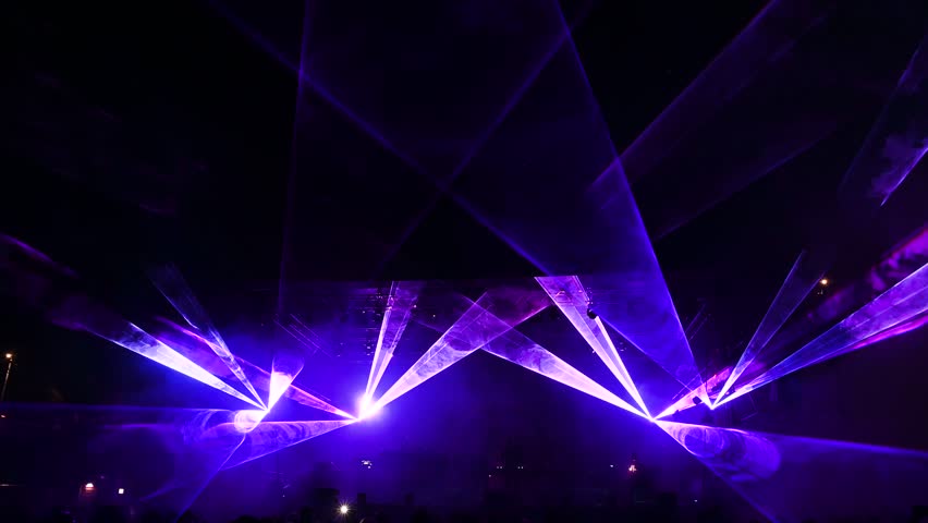 Laser lights and fog on the stage during concert. Multicolored light show at night. Abstract background. Laser beam.