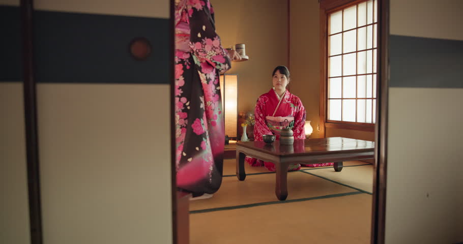 Japanese women, traditional tea ceremony and friends with respect, kindness and relax with bow at table. Girl, people and together for drink, matcha or indigenous clothes with cup, culture and home Royalty-Free Stock Footage #3410577671