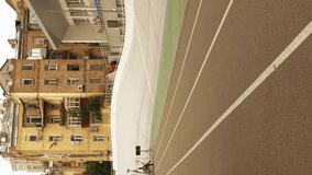 Man pushing track cyclist, helping to start ride on fixed gear bicycle on open velodrome. Cycling track. Vertical video