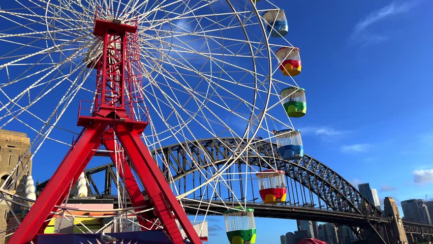 colourful Ferris wheel in Sydney amusement Theme Park with Sydney harbour Bridge in the background NSW Australia 