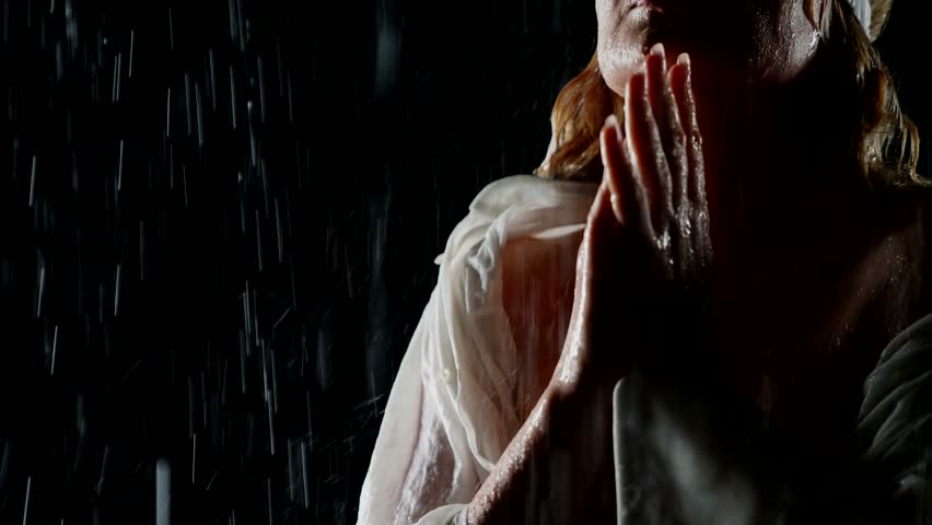 portrait of blindfold woman with sleeping mask on eyes standing alone in rain in darkness