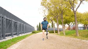 Low angle view video with copy space of a disabled athletic man running with prosthetic leg in a park