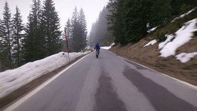 Senior man cycling on mountain road in winter