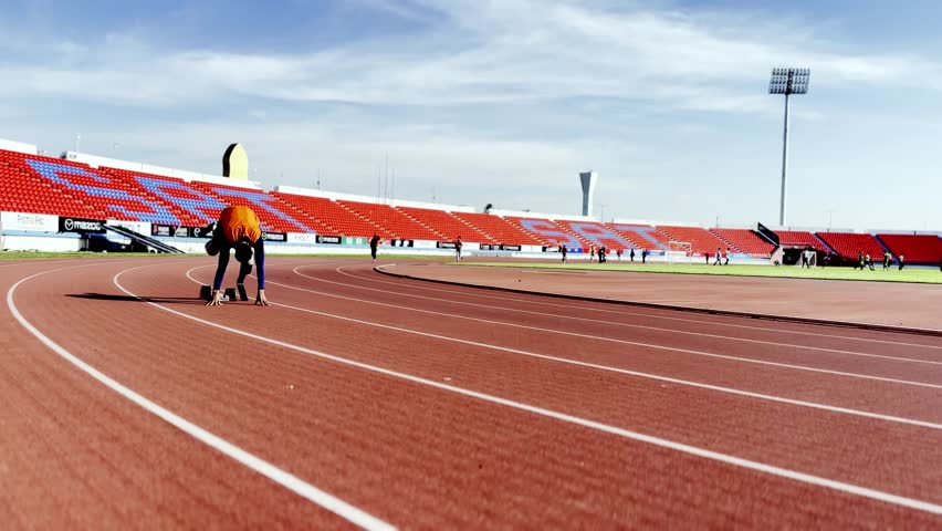 Asian para-athletes with prosthetic blades sprint on a running track at stadium.