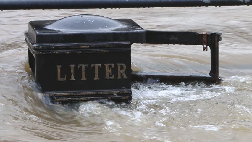 Close up of flood water from the River Severn flowing around a litter bin at Bewdley. Worcestershire. Winter. 2023. UK
