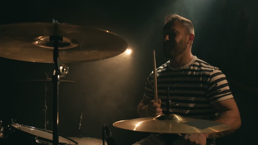 Male drummer hits the drums. Drummer rehearsing on drums in a dark studio. Music or song recording. Close-up Royalty-Free Stock Footage #3411082009