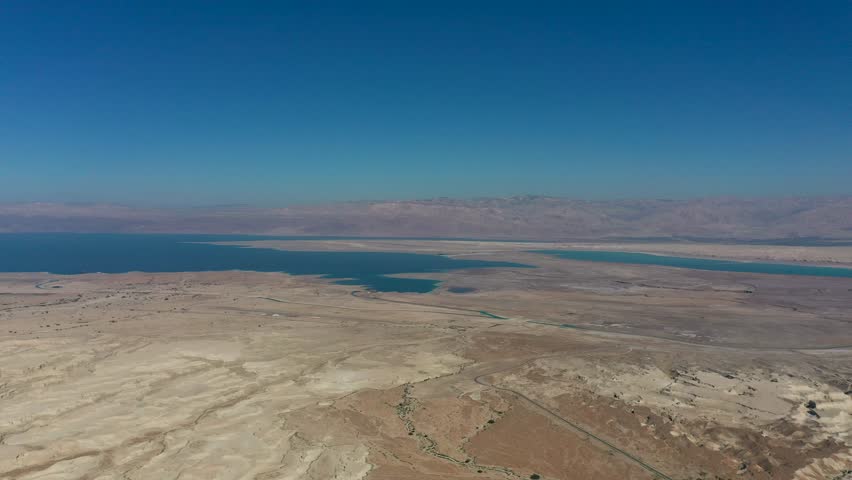 Aerial panoramic view of the Dead Sea and the ancient fortification Masada in the Southern District of Israel situated on top of an isolated rock plateau, eastern edge of the Judaean Desert, Israel