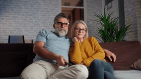Scared baby boomer couple watching horror movie on tv holding remote control at home, frightened old man and woman feeling fear or surprise during thrilling scary film moment sitting on sofa at home - Powered by Shutterstock - Get 15% off with code: PIKWIZARD15