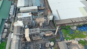 At the entrance of the paper and packaging factory, a cacophony of machinery echoes through the air, a testament to the relentless work of automation in the world of packaging production. Drone view.
