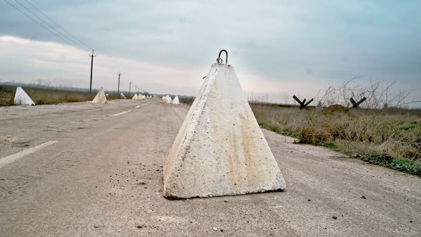 Defensive war concrete structures. Anti-tank hedgehogs on the road. Ukraine Russian war.