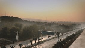 a timelapse of traffic in islamabad on a Sunny smoky day 