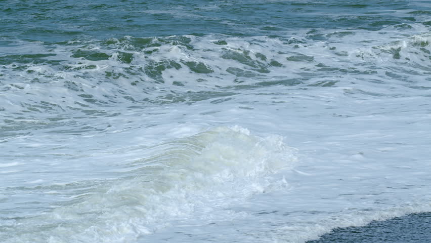 Foam Blue And Green Waves On Gray Sand. Choppy Sea Captured With Telephoto Lens. Rough Sea With Storm. Slow motion. Royalty-Free Stock Footage #3411626559