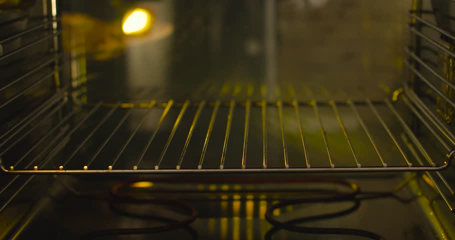 A hungry man coming from work throws a pizza into the oven for a quick roast.  