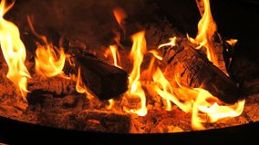 Slow-motion video of fire and flames. A fire pit, burning gas or gasoline burns with fire and flames. Flames and burning sparks close-up,fire patterns