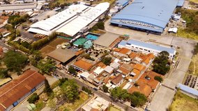 Drone footage. Aerial shot of public swimming pool in the middle of an industrial area. Aerial top view urban cityscape with public swimming pool surrounded by factories. Aerial Shot from a drone
