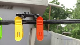 Toy cars on the hanging clips with rain 