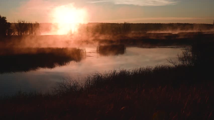 Colorful fog over the lake in autumn at dawn