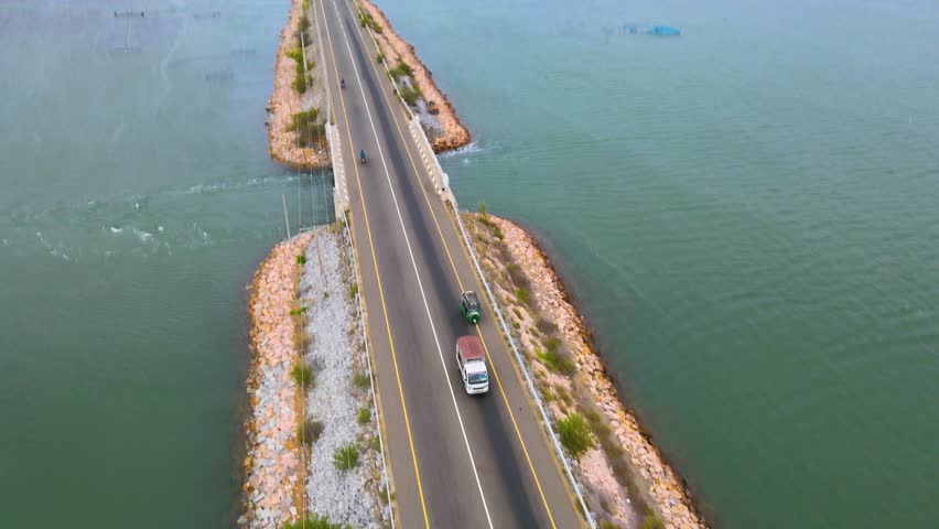 Aerial view of road with cars between blue sea and shrimp cultivation sites in Jaffna Sri Lanka