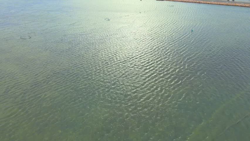 Aerial view of road with cars between blue sea and shrimp cultivation sites in Jaffna Sri Lanka