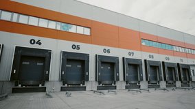 Industrial Warehouse Loading Bays. Section of an industrial warehouse, highlighting the uniform loading bays numbered from four to ten under a partly cloudy sky - Powered by Shutterstock - Get 15% off with code: PIKWIZARD15