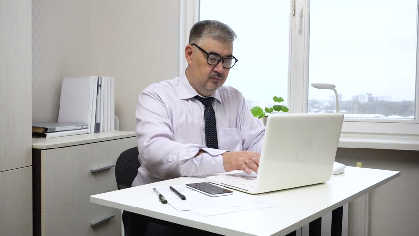 
A middle-aged man is tired from working at the computer and is rubbing his stiff neck.Ideal for content about office work, workplace ergonomics,time management methods and maintaining employee health Royalty-Free Stock Footage #3412164243