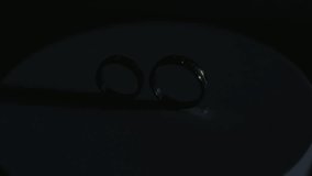 A pair of Gold wedding rings rotate with the direction of the light from the side, a strong light shadow - Powered by Shutterstock - Get 15% off with code: PIKWIZARD15