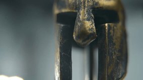 A close-up macro shot of a Spartan design, two different ancient warrior metal bronze helmets, textured shapes, studio lighting, Full HD cinematic video, hyper Slow Motion 120 fps, pan right - Powered by Shutterstock - Get 15% off with code: PIKWIZARD15