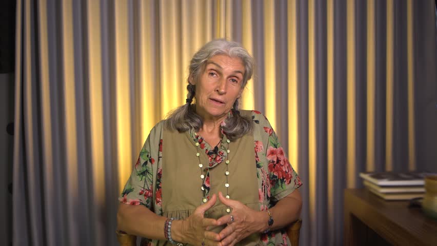 Happy mature woman psychologist talking to camera at studio. Video recording of a psychology training course. Cheerful middle aged older lady waving hand chatting speaking looking at camera. Royalty-Free Stock Footage #3412357699