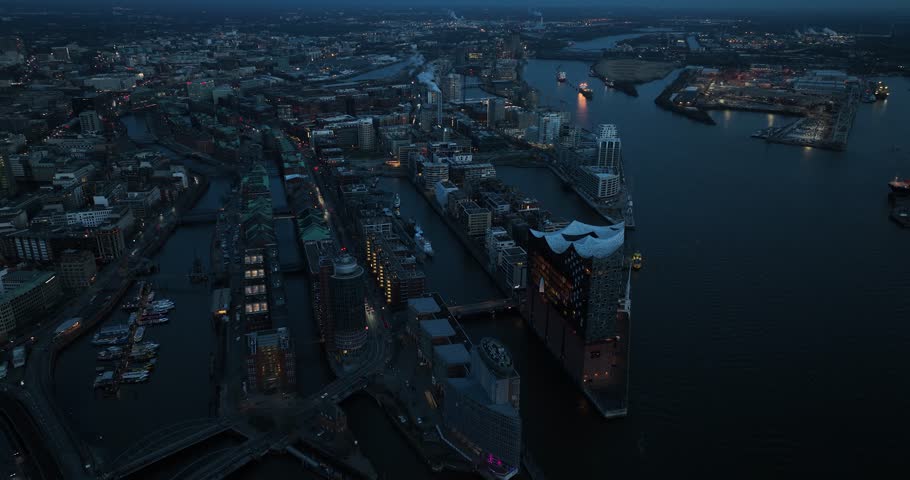 Birds eye view on the city of Hamburg, Hafen city, Elbphilharmonie concert hall and river Elbe at dusk. Night time drone view. Residential buildings.