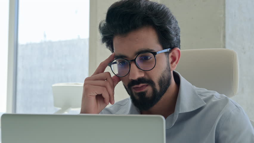 Pensive ethnic man Arabian Indian muslim businessman male employer corporate CEO at office with computer laptop business work planning thinking solve issue think ponder idea problem solution look away Royalty-Free Stock Footage #3412475191