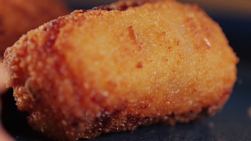 Spanish tapas, Fried portuguese croquettes close-up macro. Breaded croquette of fish, potatoes and ham. Man cooking spanish food.  Royalty-Free Stock Footage #3412495979