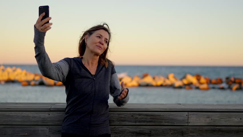 Video of a happy senior couple taking a selfie after running in the promenade