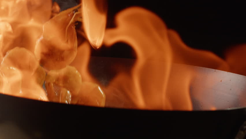 Chef cooking flambe shrimps with oil on wok frying pan close-up. Prawns on fire throwing them in pan. Restaurant Food concept. Sea food.