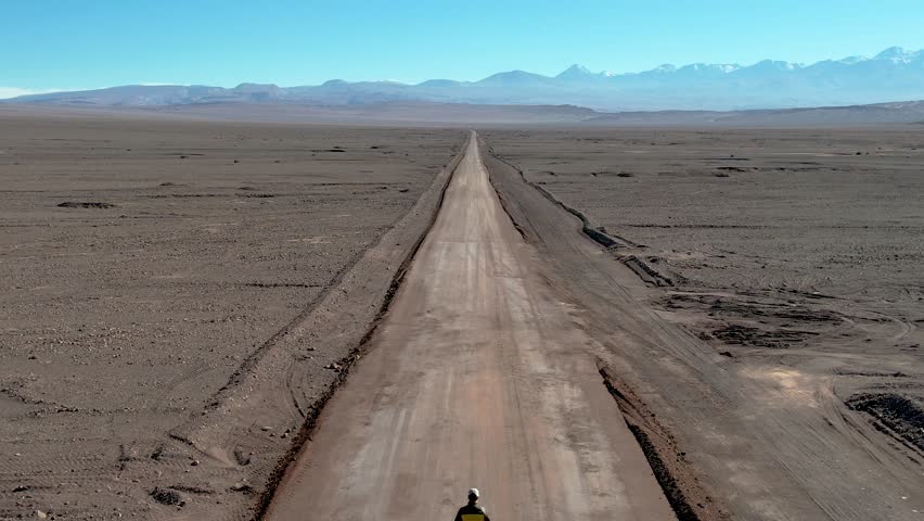 Beautiful aerial footage of the a person walking alone in the Atacama Dessert - Calama - Antofagasta Dessert and Salar - turquoise lagoon.