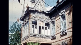 Beautiful wooden building architecture in summer outside. Russian traditional tower. Windows decorated with carvings. National cultural heritage. Vintage color film. Retro archive. Russia 1980s Nobody