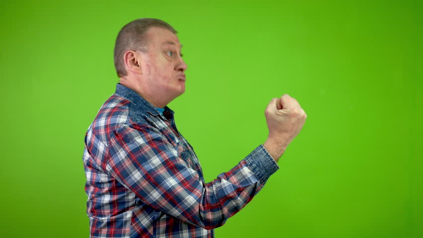 Disgruntled senior caucasian man threateningly showing fist and shakes finger.