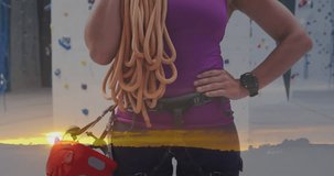 Animation of sunset over caucasian woman by climbing wall. Global sports, science, computing, digital interface and data processing concept digitally generated video.