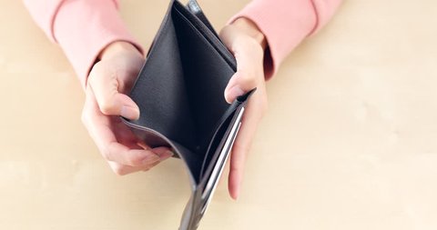 Woman opening empty wallet 