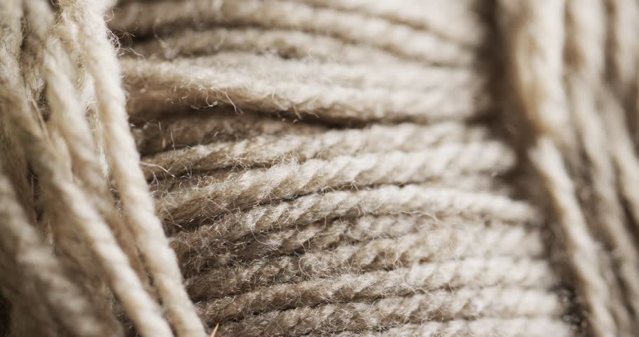 Close-up view of a textured, twisted natural fiber rope, with copy space. Its detailed fibers and strands highlight the strength and durability of the material. Royalty-Free Stock Footage #3412822515