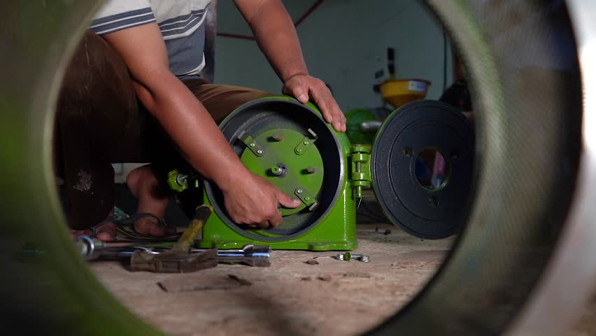 clipart video up close, a technician assembling a rice grinding machine.