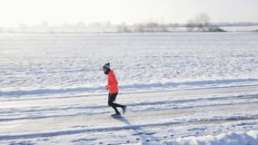 Male runner jogging on winter snowy road, preparing for competition. Winter running exercises. Athlete training at cold frozen day - Powered by Shutterstock - Get 15% off with code: PIKWIZARD15