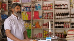 A portrait shot of a happy Indian grocery store owner posing at his retail shop - fmcg products. A successful Indian kirana or grocery businessman standing confidently with a smile - small business... - Powered by Shutterstock - Get 15% off with code: PIKWIZARD15