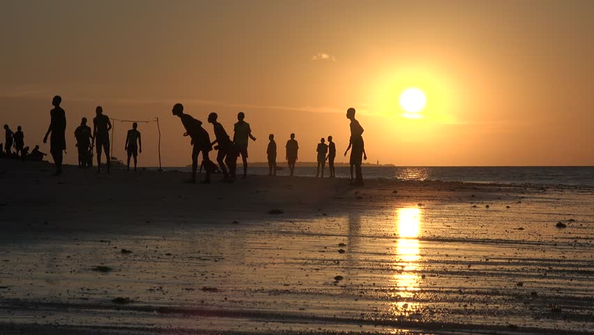 People playing beach soccer. Silhouettes of young guys playing beach soccer. Young men playing beach football at sunset on the beach near the ocean. Healthy lifestyle concept Royalty-Free Stock Footage #3412951835