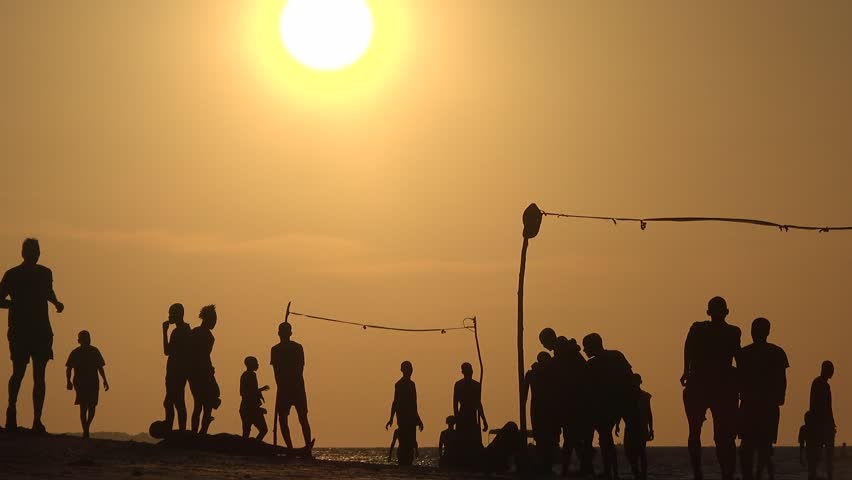 People playing beach soccer. Silhouettes of young guys playing beach soccer. Young men playing beach football at sunset on the beach near the ocean. Healthy lifestyle concept Royalty-Free Stock Footage #3412951895